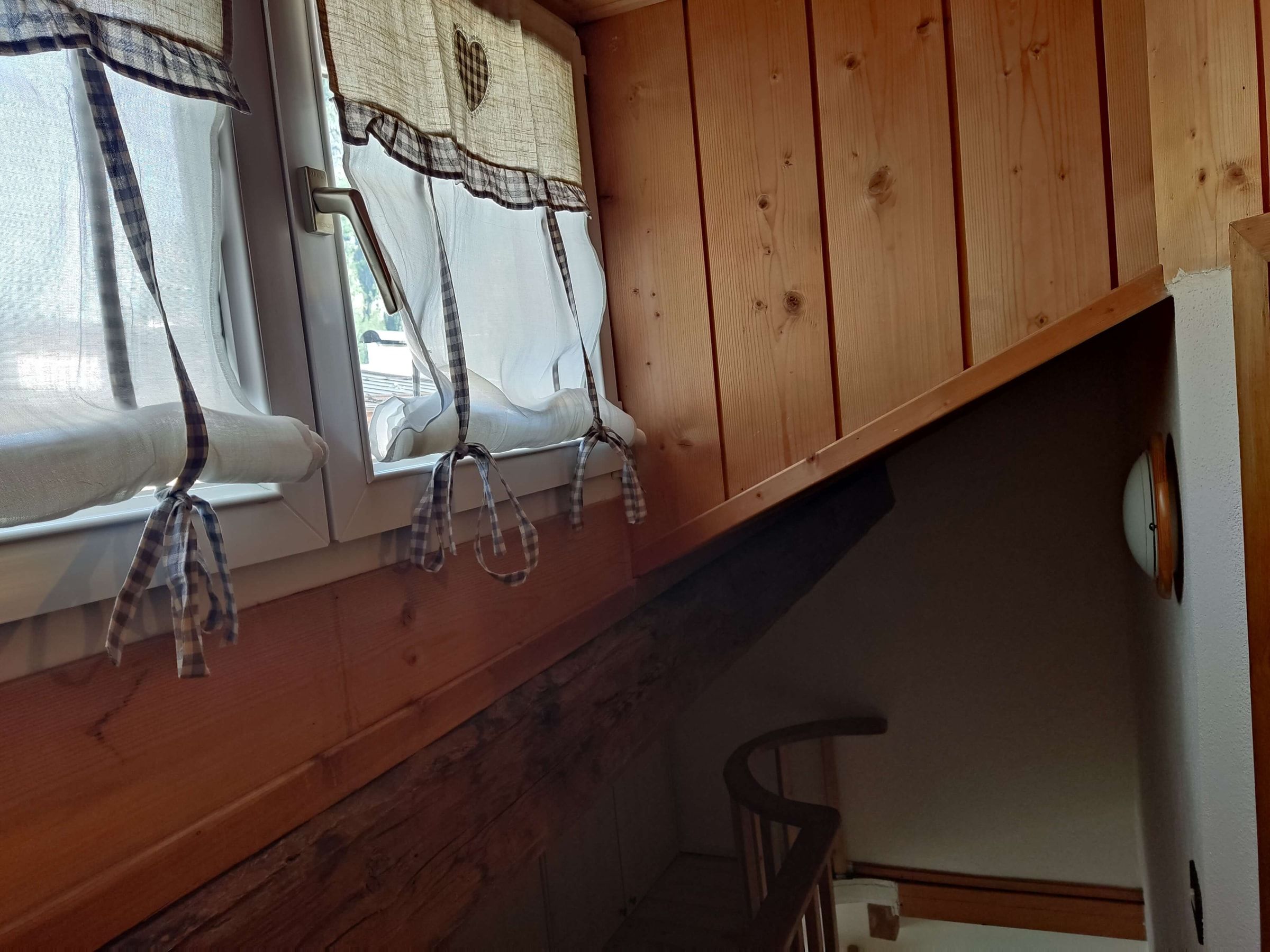Gaubenfenster mit karierten Vorhängen