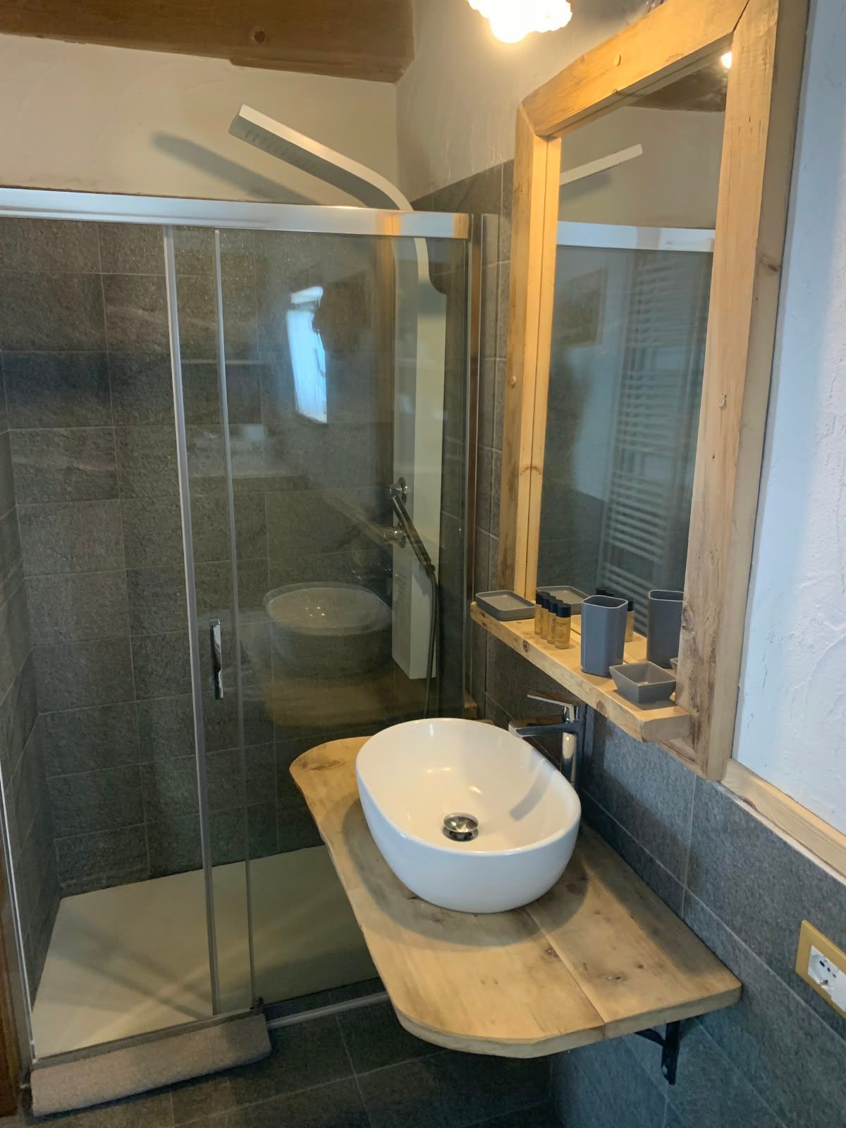Bad mit Glasdusche, Aufsatzwaschbecken auf Holzablage und Spiegel
