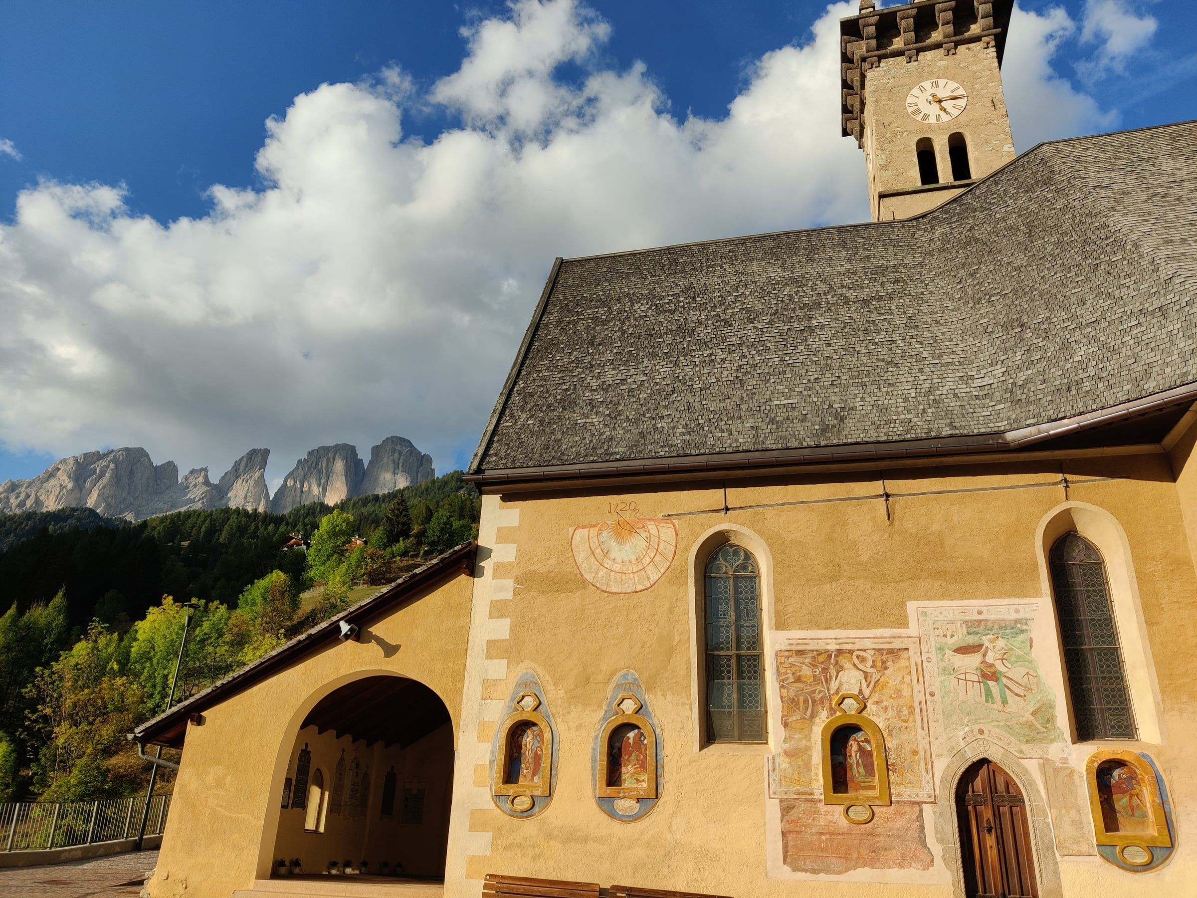 Chiesetta affrescata con le Dolomiti sullo sfondo, in Val di Fassa