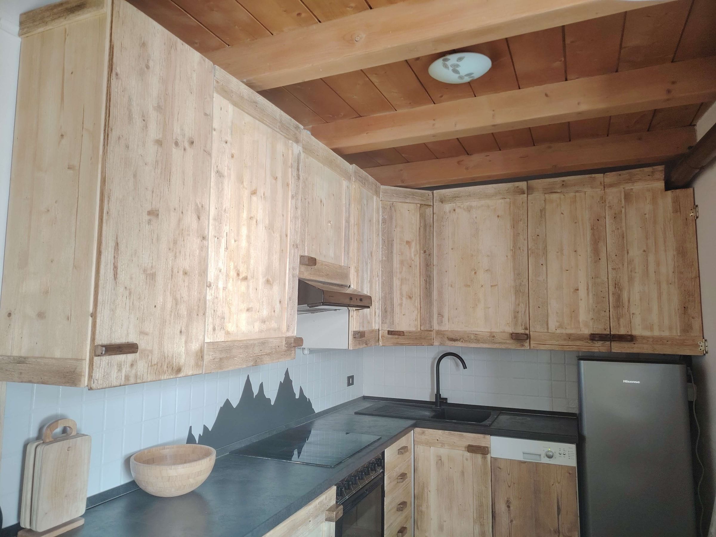 Küche aus Naturholz mit Kochfeld, Backofen und Kühlschrank