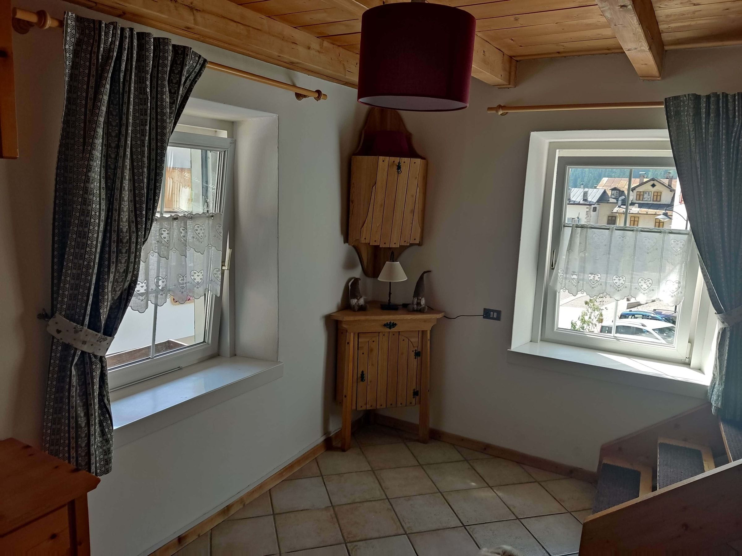 Wohnzimmer mit Blick aufs Dorf und Möbeln im ladinischen Stil