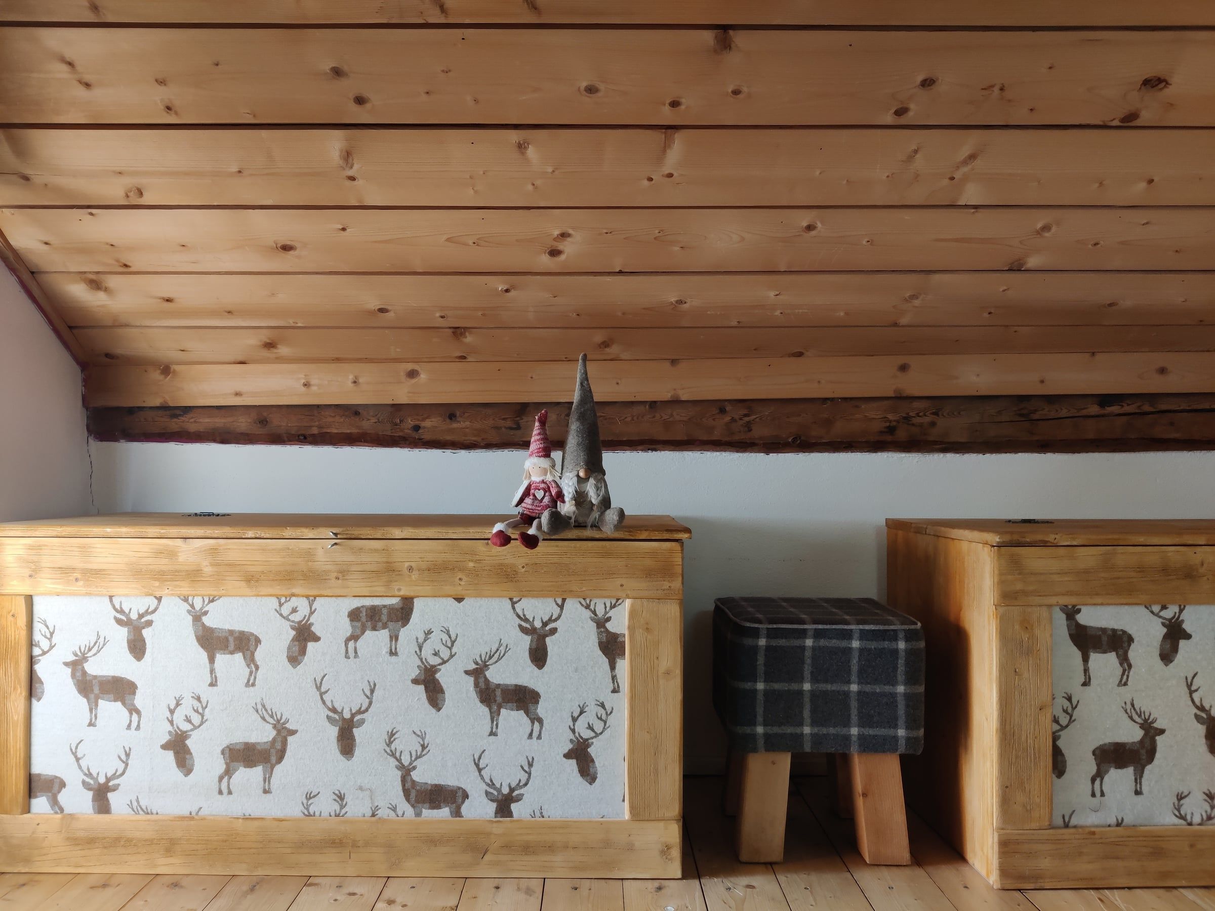 Angolo nel sottotetto con panche in legno decorate a cervi